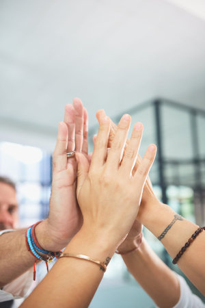 The practice of collaboration always works best. a team of doctors joining their hands together in a...