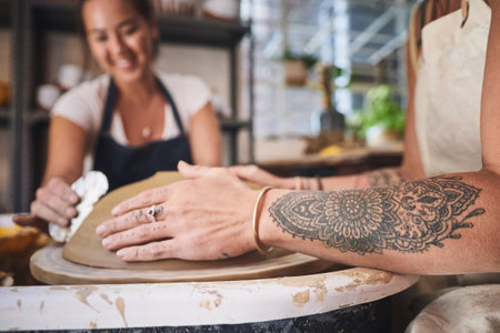 You learn something new everyday. two young women working with clay in a pottery studio.の写真素材