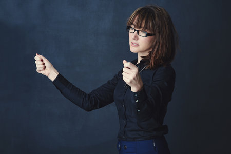 Holding on to her plans for success. Studio shot of a corporate businesswoman pretending to hold something against a dark background.の写真素材