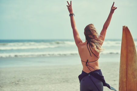 Surfing is everything. a beautiful young woman going for a surf at the beach.