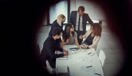 Monday is meeting day. a group of colleagues using digital tablet together during a meeting in a modern office.の写真素材