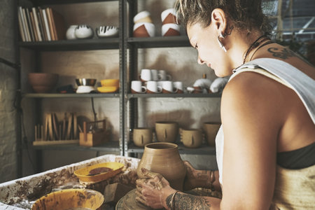 Creativity is a gift you get to use everyday. a young woman working with clay in a pottery studio.の写真素材