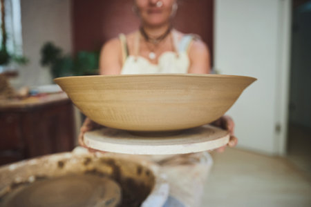 Throw your pot in the air like you just dont care. a woman making a bowl in a pottery studio.の写真素材