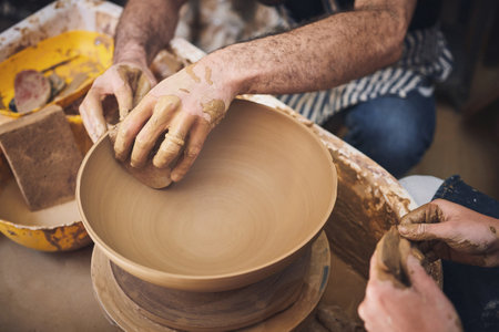 The ancient craft of molding clay. an unrecognisable man and woman working with clay in a pottery studio.の写真素材