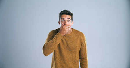 Holy moly. Studio shot of a handsome young man looking surprised against a gray background.の写真素材