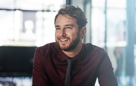 Have faith in the business vision. a confident young businessman looking thoughtful in a modern office.の写真素材