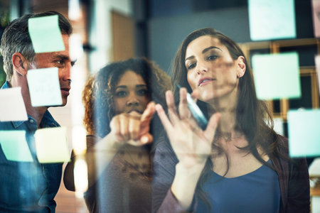 Working through ways to increase their profit margin. a group of businesspeople brainstorming with...