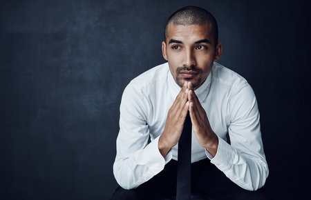 Are there more avenues to success still to be discovered. Studio shot of a young businessman looking thoughtful against a dark background.の写真素材