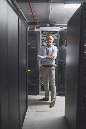 The man skilled in multiple systems. Portrait of a mature man working in a server room.
