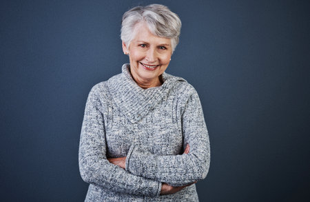 Aging is a wonderful process. Studio shot of a cheerful elderly woman standing with her arms folded while looking at the camera.の写真素材