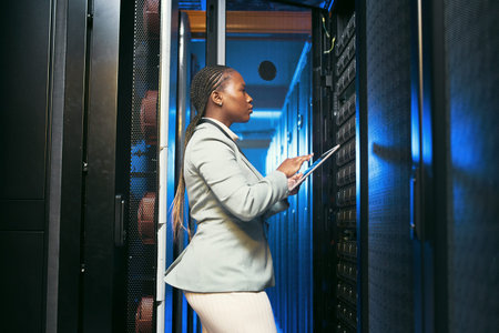 Keeping the future of technology intact. a young IT specialist standing alone in the server room and...