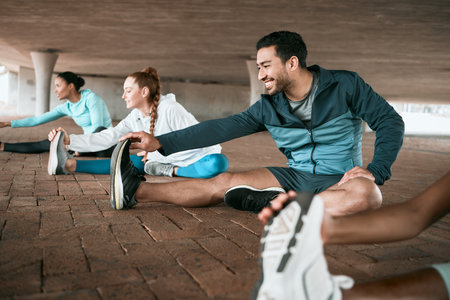 Group, workout and people stretching as a fitness club for sports, health and wellness in an urban town together. Sport, smile and happy friends training or team doing warm up exercise in a cityの写真素材