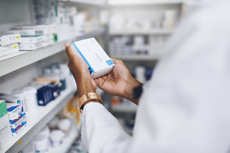 This is just what my customer needs. an unrecognizable pharmacist picking medication from the shelves.の写真素材