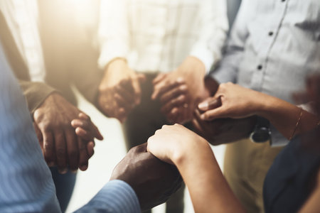 Reach out and help one another to succeed. Closeup shot of a group of businesspeople holding hands.