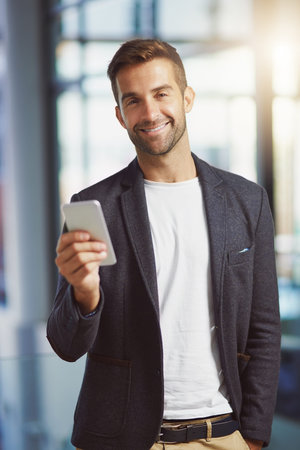 This contact will help me make this a success. a businessman using his cellphone at the office.