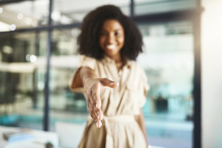 Lets shake and call it a deal. Portrait of a young businesswoman extending a handshake in an office.の写真素材