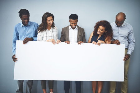 This is something worth supporting. Studio shot of a group of businesspeople holding a sign against...