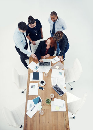 Could you explain how this works...group of businesspeople using a laptop together during a meeting in an office.の写真素材