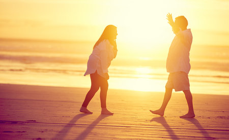 May I have this dance. Full length shot of an affectionate mature couple dancing on the beach at sunset.の写真素材