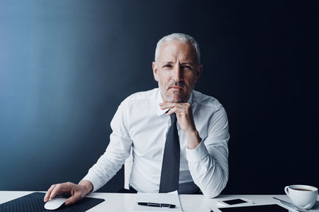 His work is his first priority. Cropped portrait of a mature businessman working on his computer.の写真素材