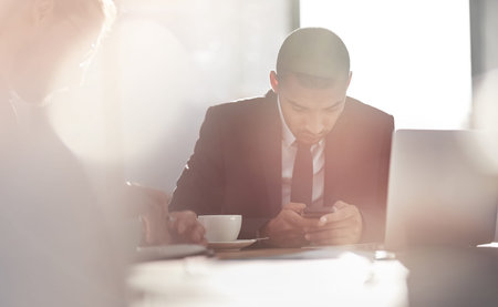 Ready for business. a young businessman using his smartphone at work.