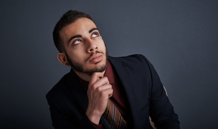 Setting his sights on greater heights. Studio shot of a stylish young businessman looking thoughtful...