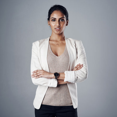 Nothing stands in my way of having a successful career. Studio portrait of a young businesswoman posing against a gray background.の写真素材