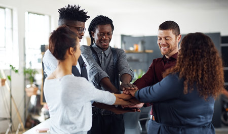Bring it in for another team success. a group of businesspeople joining their hands together in a...