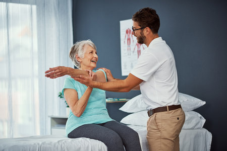 Keep that there for a second. a senior woman working through her recovery with a male physiotherapist.の写真素材