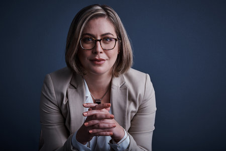 Success takes dedication. Studio portrait of an attractive young corporate businesswoman posing against a dark background.の写真素材
