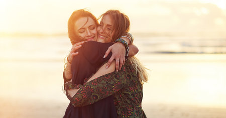 Be yourself and the right people will love you. two young women spending the day at the beach at sunset.の写真素材
