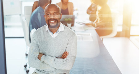 Im here to succeed and only succeed. a businessman posing with his arms crossed in a boardroom.の写真素材