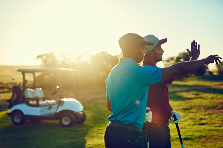 Life is better when youre golfing. two friends playing a round of golf out on a golf course.の写真素材