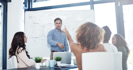 Together we make things happen. a businessman delivering a presentation to his colleagues in a boardroom meeting.の写真素材