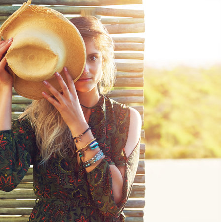 Be your own mantra. a young woman holding a hat over her face.の写真素材