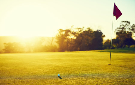 Sink it to win it. a golf ball and flag on an empty course.の写真素材