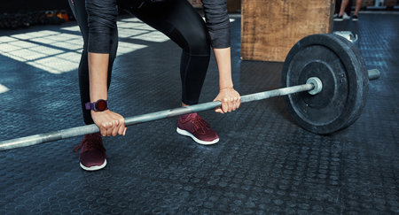 You have to lift to be strong. an unrecognizable woman lifting weights in a gym.の写真素材