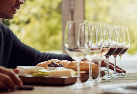 Wine tasting, cheese platter and luxury restaurant with alcohol and glass for customer. Eating, drink and sommelier with bottle for wines and food pairing in a fine dining and winery experienceの写真素材