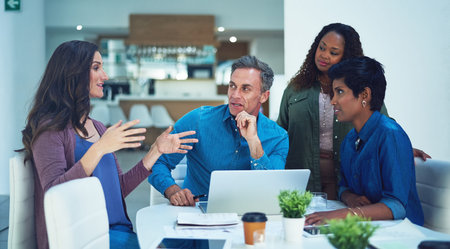 So how do you think we can fix this. High angle shot of a group of designers having a meeting in an...