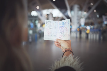 Stamp chaser. a woman showing her passport stamps at the airport.の写真素材