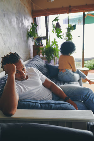 What did I do wrong. a young man looking upset after an argument with his partner at home.の写真素材