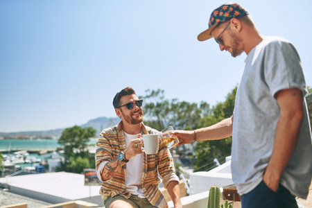 It was a good idea to go outside. two cheerful young men enjoying a cup of coffee together outside...