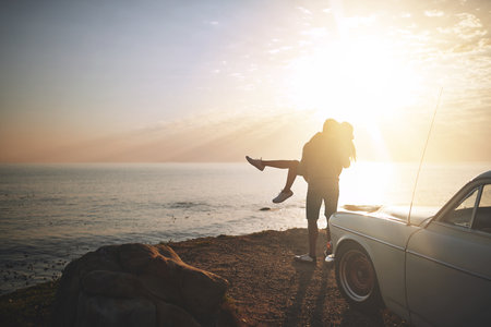 Ill do just about anything for you. a young couple making a stop at the beach while out on a road trip.の写真素材