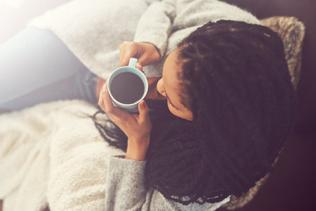 Coffee is my BFF. a young woman enjoying a cup of coffee at home.の写真素材