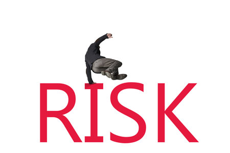 The bigger the risk, the bigger the leap of faith. a businessman jumping over the word RISK against a white background.の写真素材