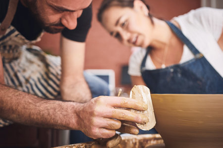 Making art is the best medicine. a young man and woman working with clay in a pottery studio.の写真素材