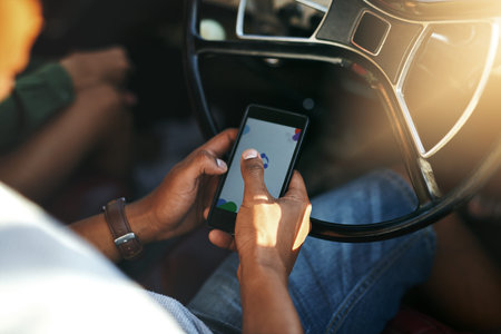 Sending a quick text before hitting the road. an unrecognizable man using his cellphone while...