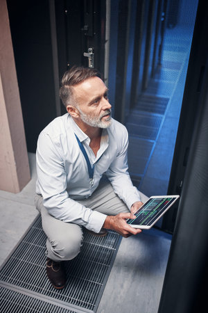 Get better internet speed with help from this IT guru. a mature man using a digital tablet while...