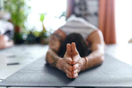 If youre feeling lost, meditation will guide you back home. a young man going through a yoga routine at home.の写真素材