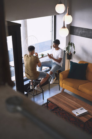 FriendsCoffee The perfect blend. two young men talking while having coffee together in a cafe.の写真素材
